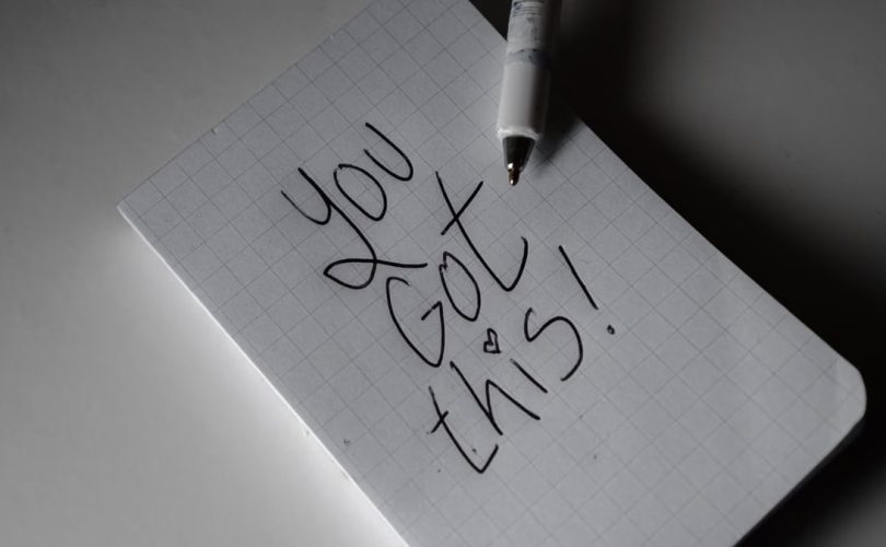 Inspirational handwritten note on graph paper with pen. Encouraging words 'You got this!'